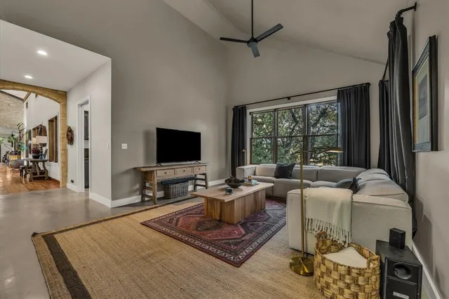 a living room with furniture a flat screen tv and a large window