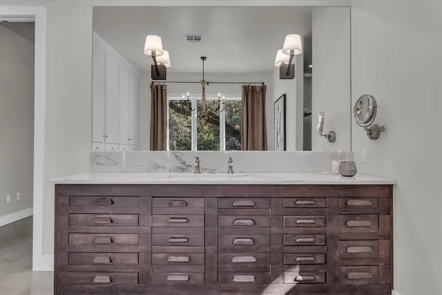 a bathroom with a granite countertop sink and a mirror