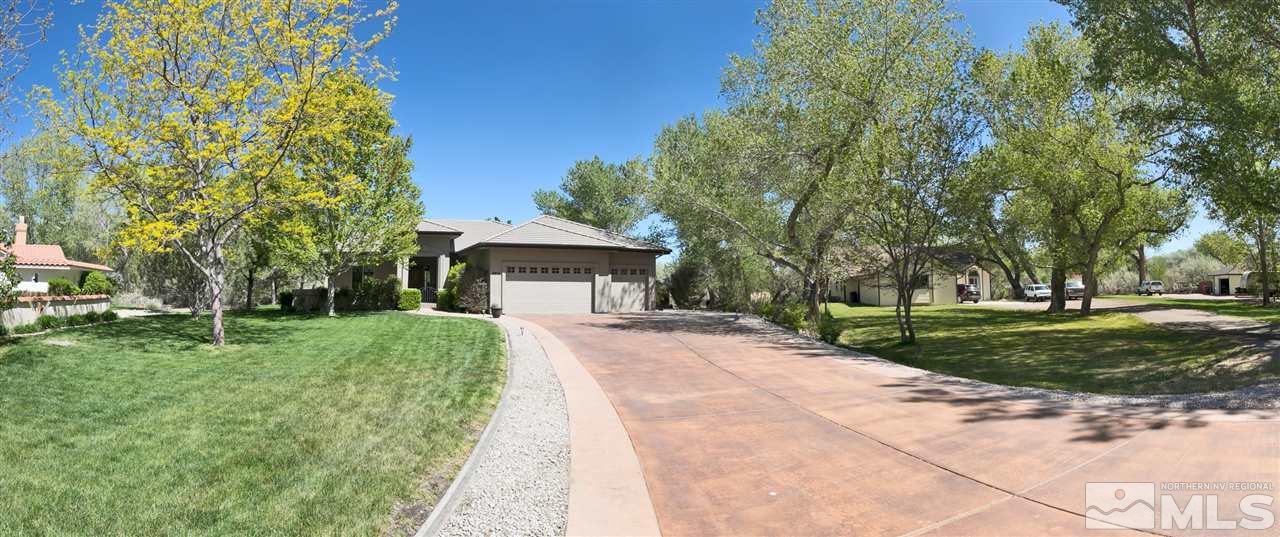 a front view of a house with a yard and trees