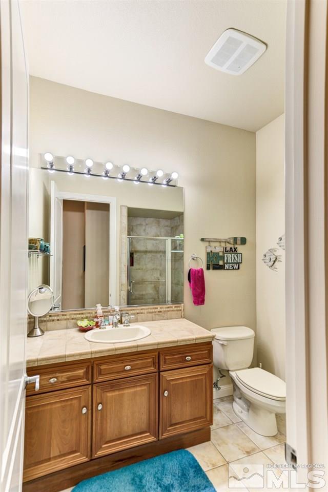5610 Rivers Edge Drive Fallon, NV 89406 - Photo 14 of 25 a bathroom with a granite countertop toilet sink and mirror