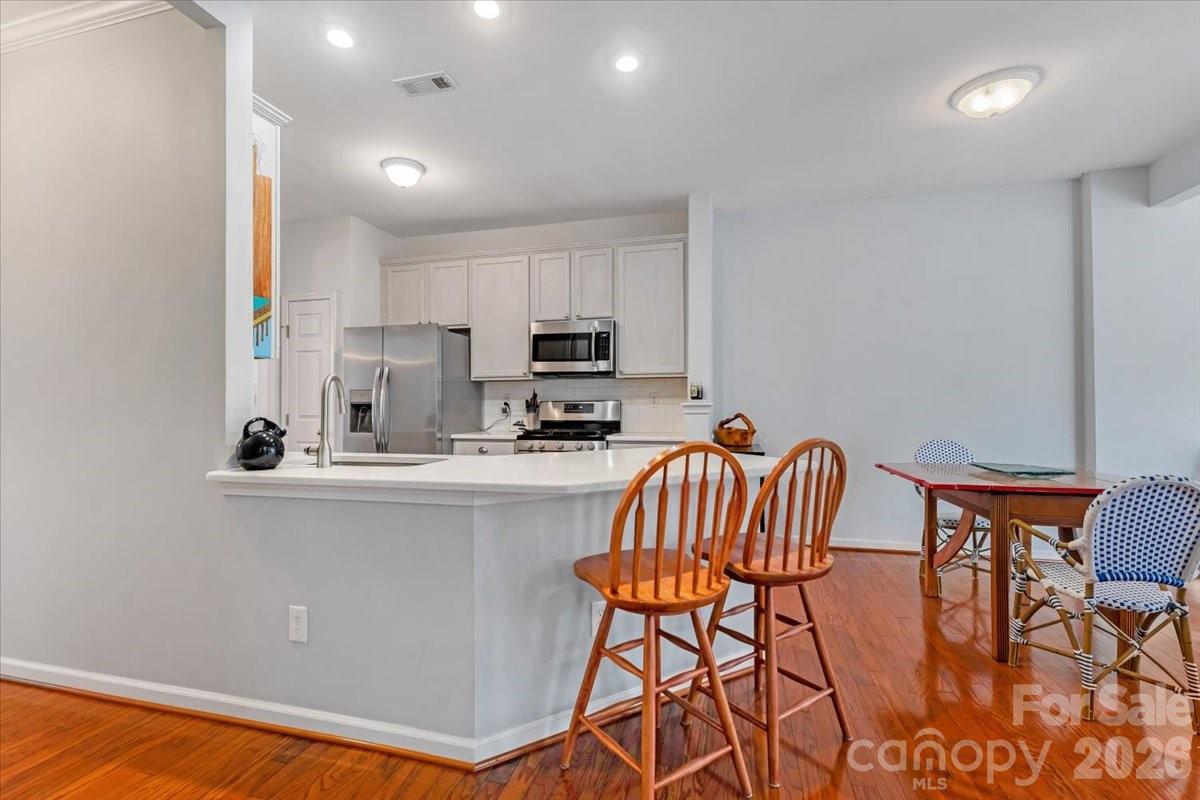 7948 Mariners Pointe Circle Denver, NC 28037 - Photo 12 of 39 a kitchen with stainless steel appliances granite countertop a dining table chairs microwave and sink