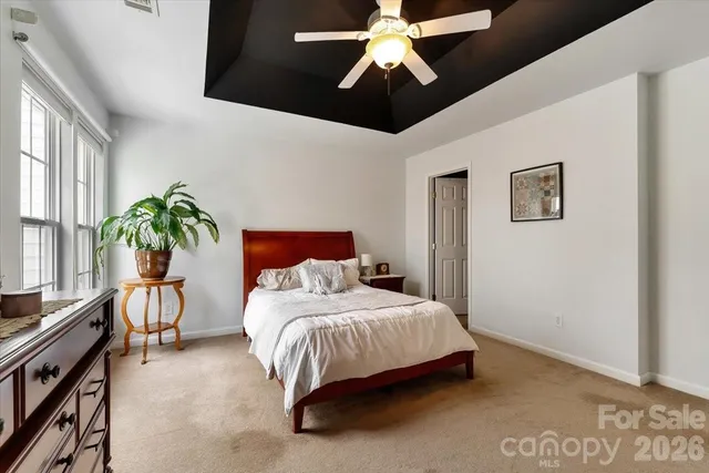 a bedroom with a bed chandelier and a window