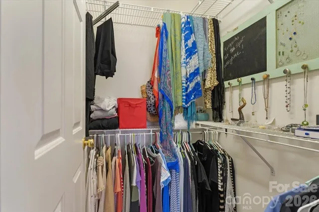 a view of walk in closet with clothes and shoes
