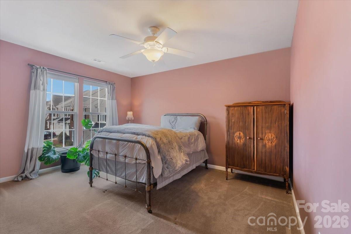 7948 Mariners Pointe Circle Denver, NC 28037 - Photo 29 of 39 a bedroom with a bed and a chandelier