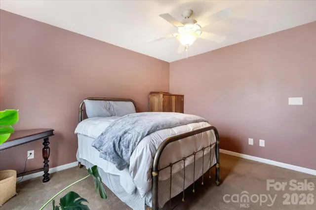 a bedroom with a bed and a chandelier fan