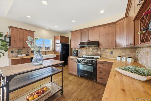 a kitchen with stainless steel appliances granite countertop a stove refrigerator sink and cabinets