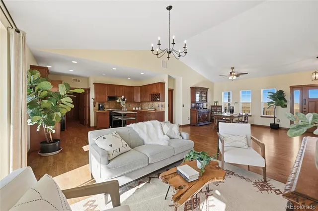 a living room with furniture kitchen view and a chandelier