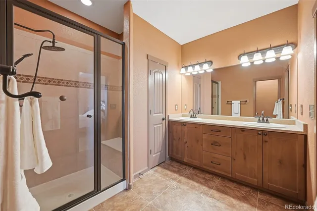 a bathroom with a double vanity sink a mirror and a shower