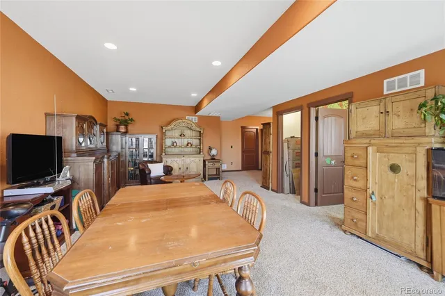a room with furniture a flat screen tv and a refrigerator