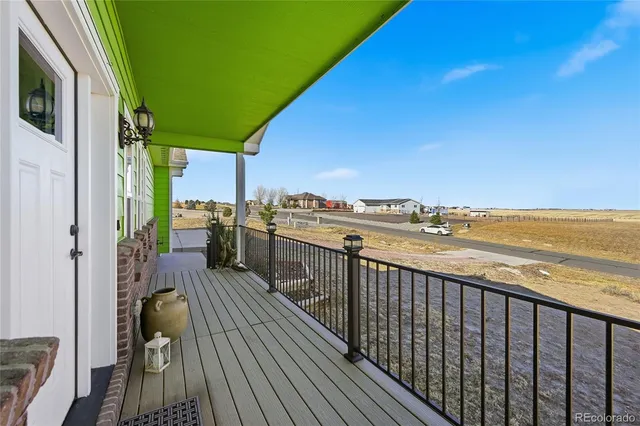 a view of a balcony with wooden floor and outdoor seating