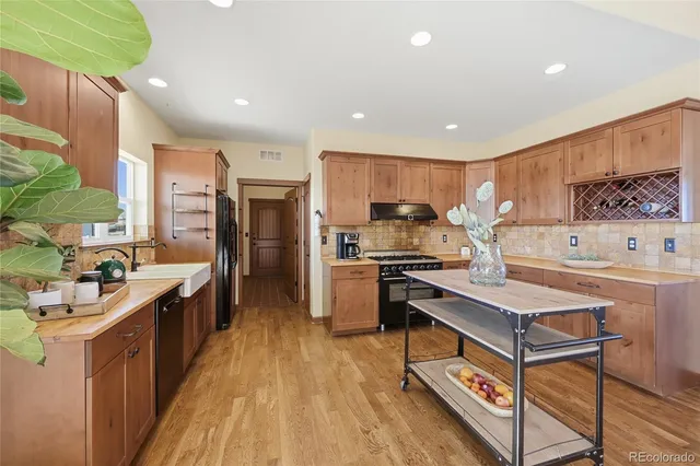 a kitchen with stainless steel appliances kitchen island granite countertop a stove a sink a refrigerator and a microwave