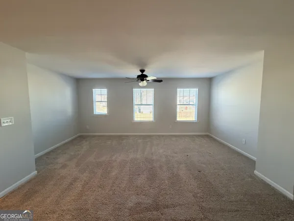 a view of a livingroom with a ceiling fan and window