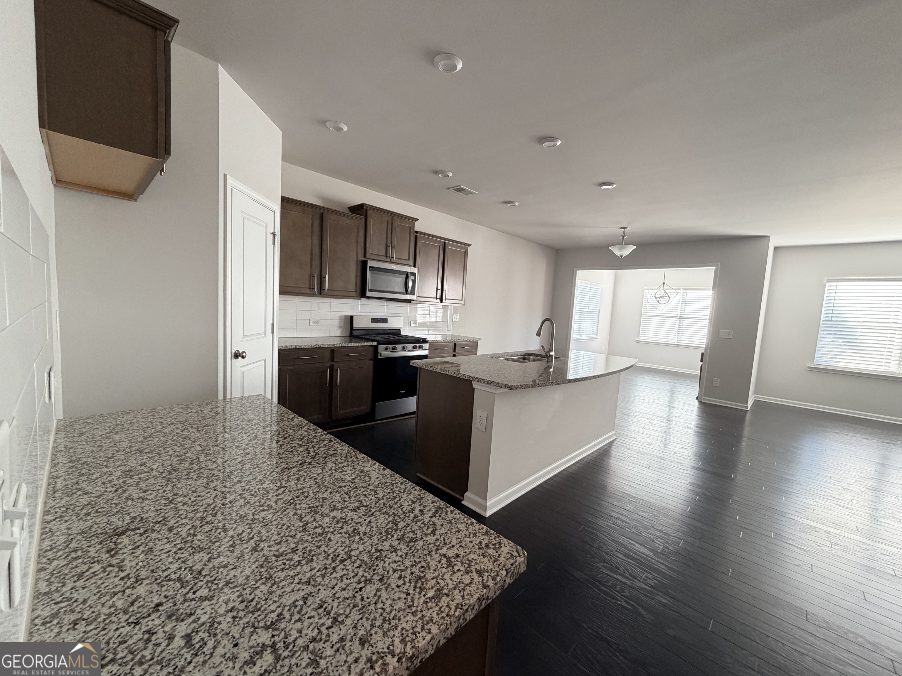 3283 Lowell Road Bethlehem, GA 30620 - Photo 3 of 31 a kitchen with stainless steel appliances kitchen island granite countertop a stove a sink and a refrigerator