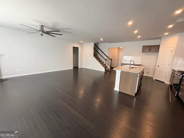 an entryway in wooden floor with a living room