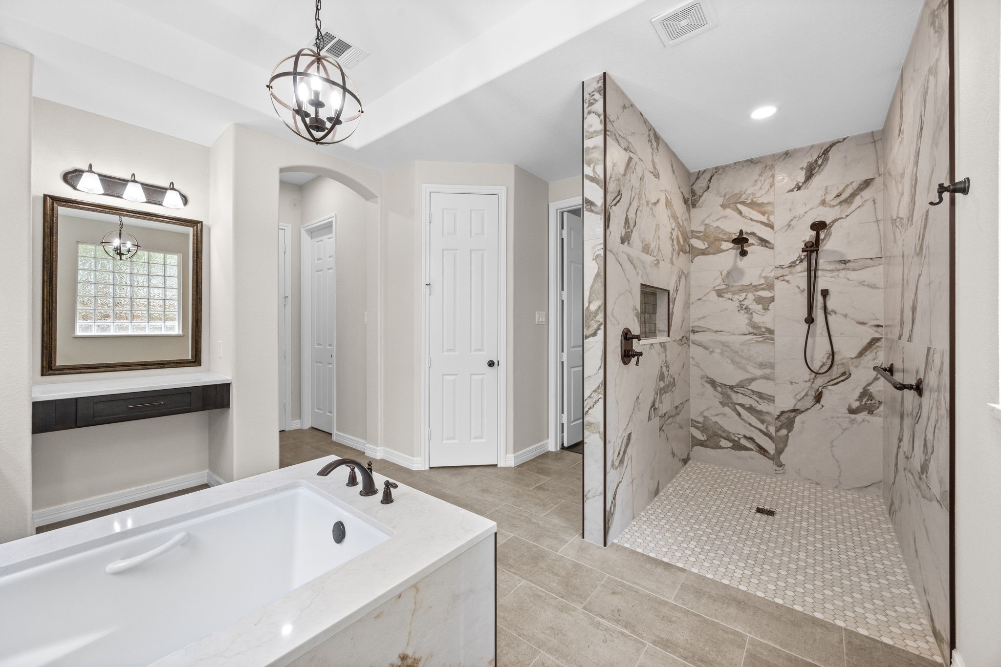 27642 Linden Ridge Lane Fulshear, TX 77441 - Photo 21 of 42 The oversized walk-in shower is beautifully appointed with dual shower heads, a handheld shower wand, a built-in shampoo niche, elegant Quartz surrounds, and stylish octagon tile flooring. This Spa-inspired shower offers both luxury and functionality, creating the perfect space to begin or end your day.