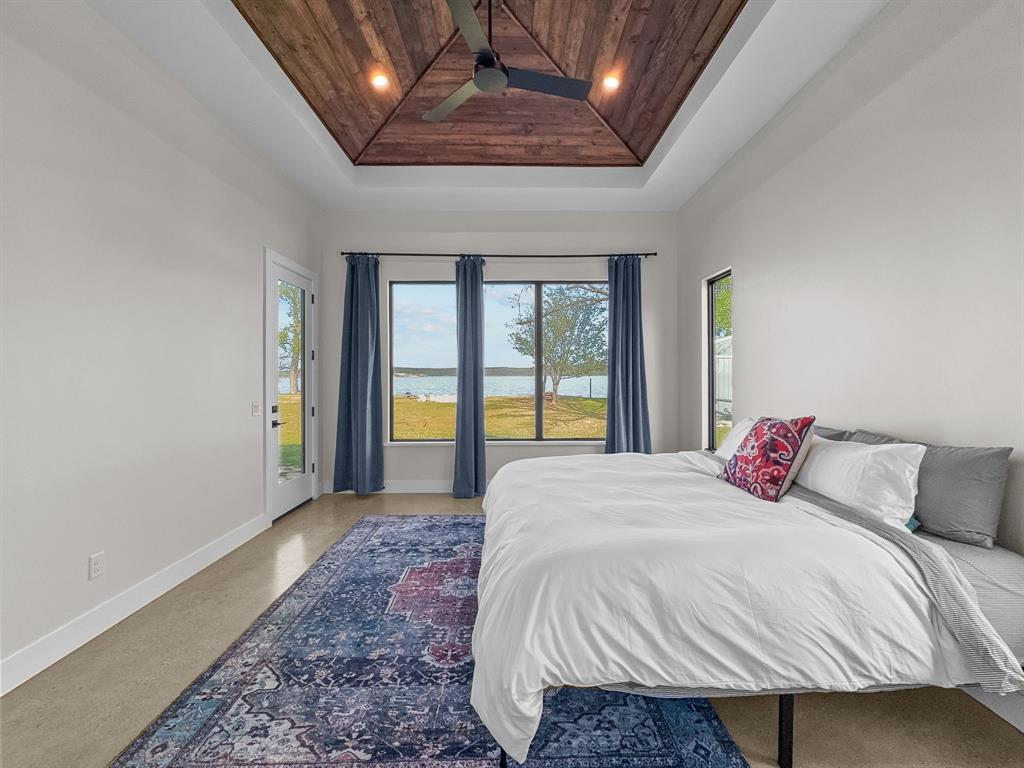 1163 Willow Road Graford, TX 76449 - Photo 13 of 31 a bedroom with a large bed and a large window
