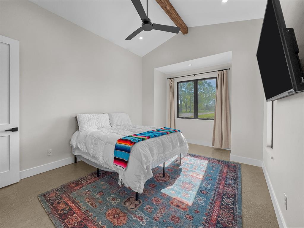 1163 Willow Road Graford, TX 76449 - Photo 20 of 31 a bedroom with a bed wooden floor and flat screen tv