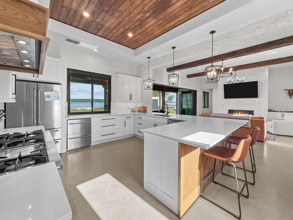 1163 Willow Road Graford, TX 76449 - Photo 9 of 31 a kitchen with stainless steel appliances kitchen island granite countertop a stove and a sink