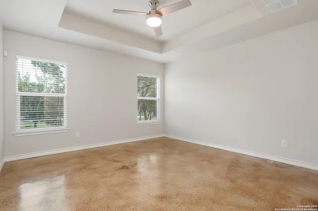 an empty room with a window and a ceiling fan