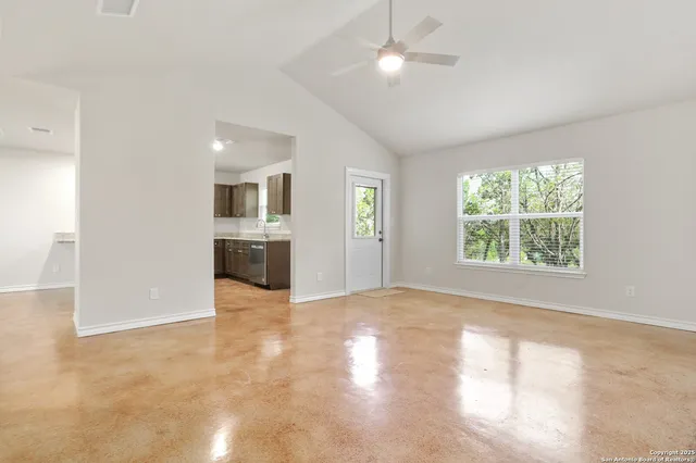 an empty room with windows and ceiling fan