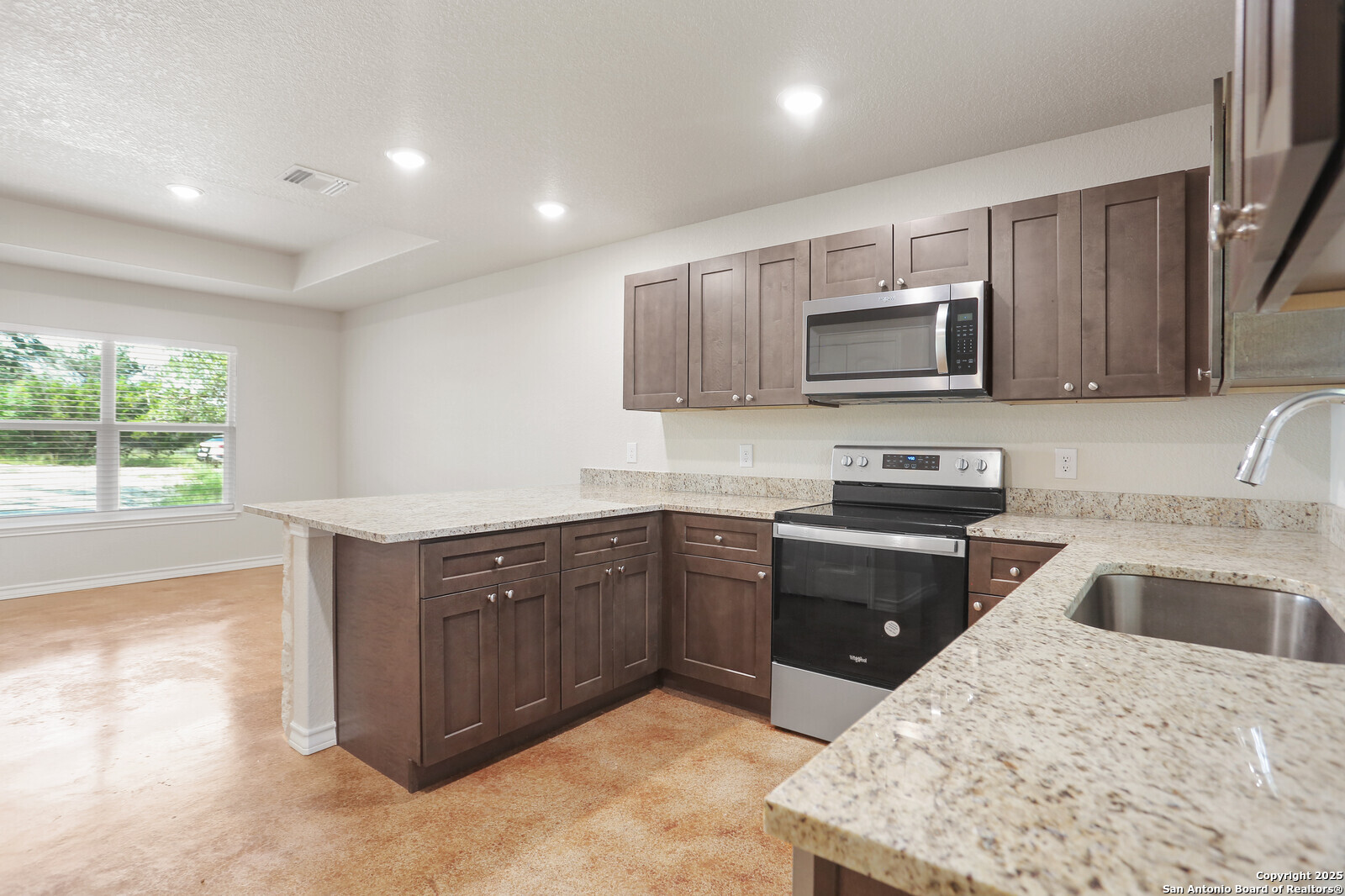 150 Hill Drive Spring Branch, TX 78070 - Photo 8 of 21 a kitchen with stainless steel appliances granite countertop a sink dishwasher stove and microwave