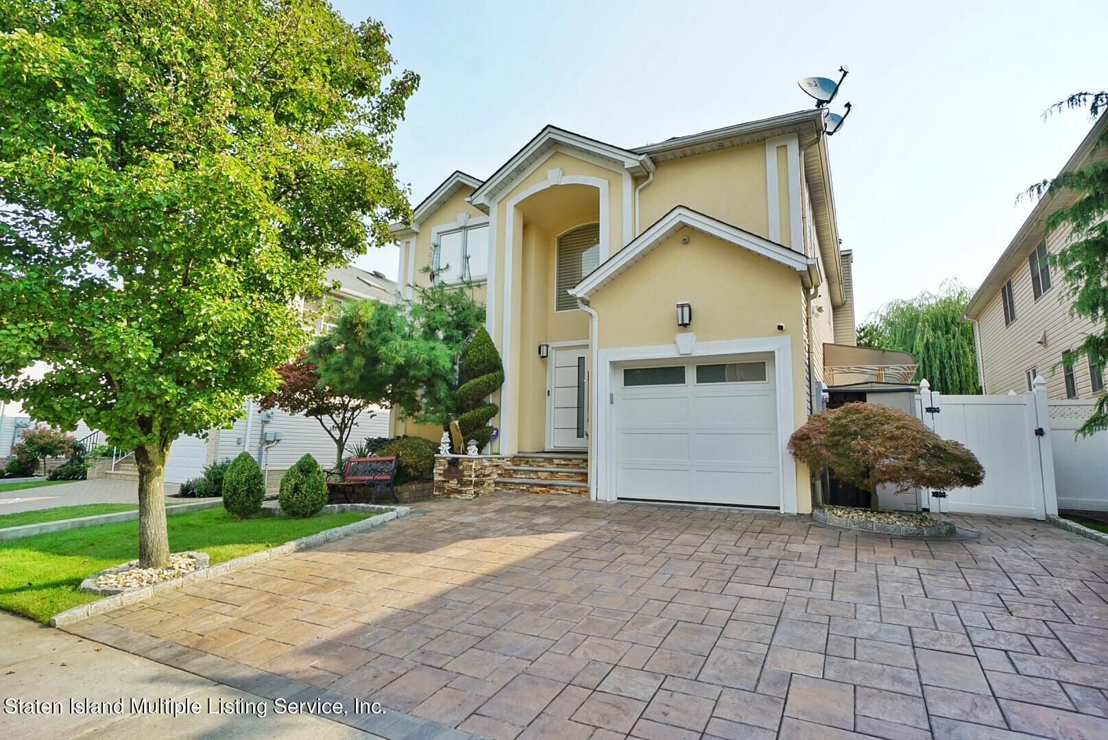 67 Covington Circle Staten Island, NY 10312 - Photo 1 of 45 a front view of a house with a yard and garage