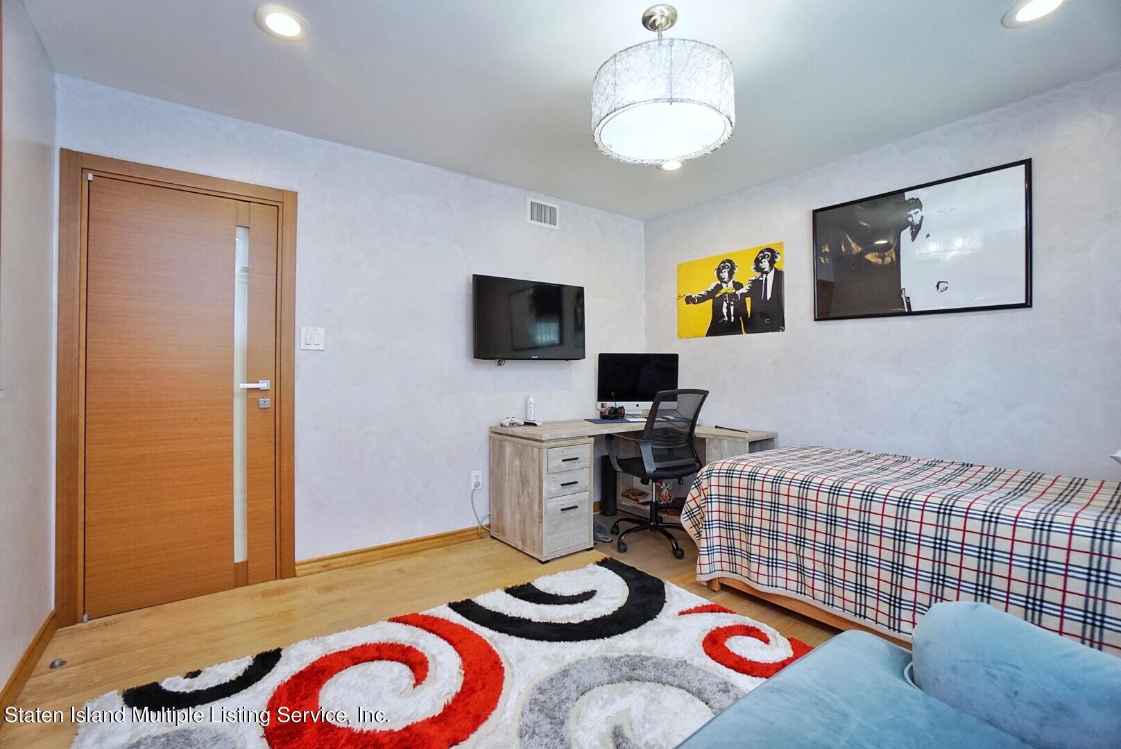 67 Covington Circle Staten Island, NY 10312 - Photo 32 of 45 a bedroom with a bed and a flat screen tv