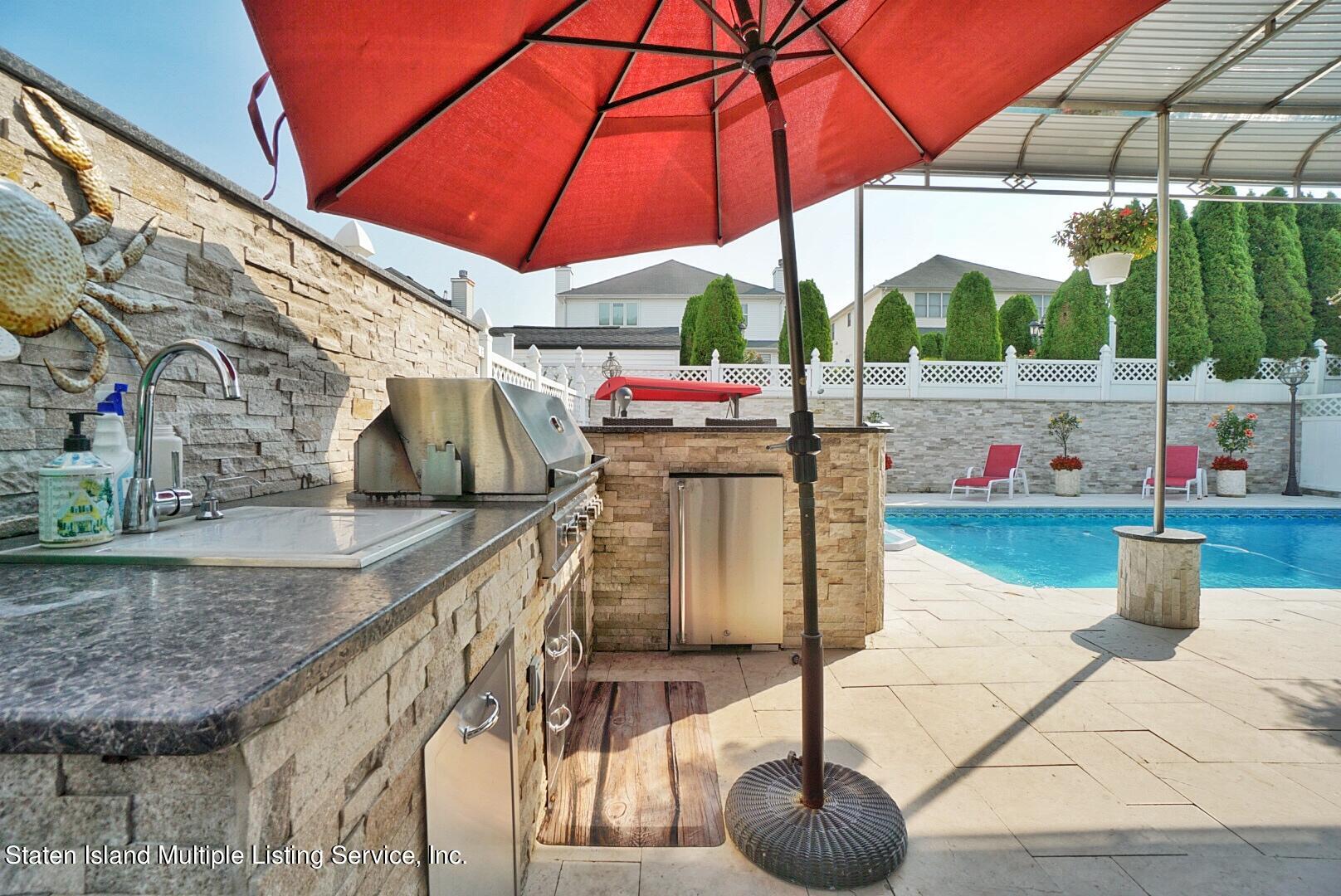67 Covington Circle Staten Island, NY 10312 - Photo 6 of 45 a view of roof deck with dining table and chairs under an umbrella
