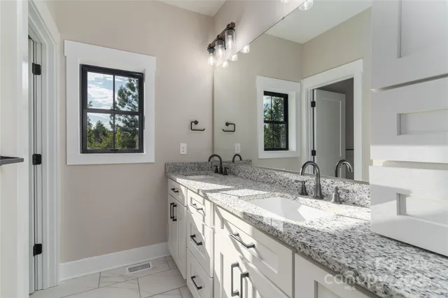 a bathroom with a granite countertop sink and a mirror