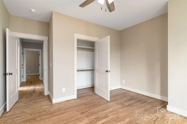 an empty room with wooden floor and chandelier