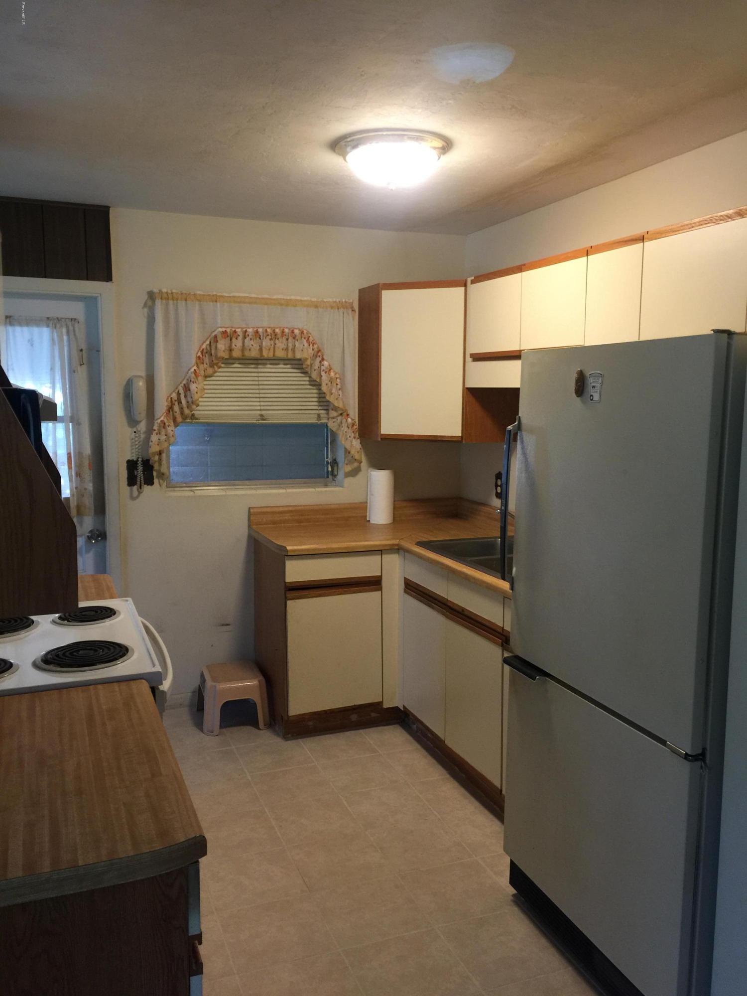 2402 Allan Adale Road Melbourne, FL 32935 - Photo 5 of 23 a kitchen with a refrigerator and a stove top oven
