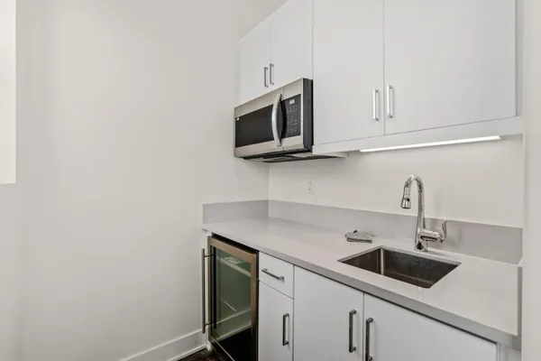 a kitchen with stainless steel appliances granite countertop a sink and a microwave with wooden floor
