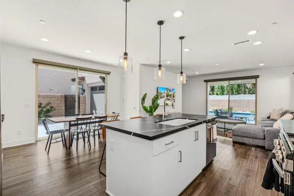 a kitchen with a table chairs stove and wooden floor