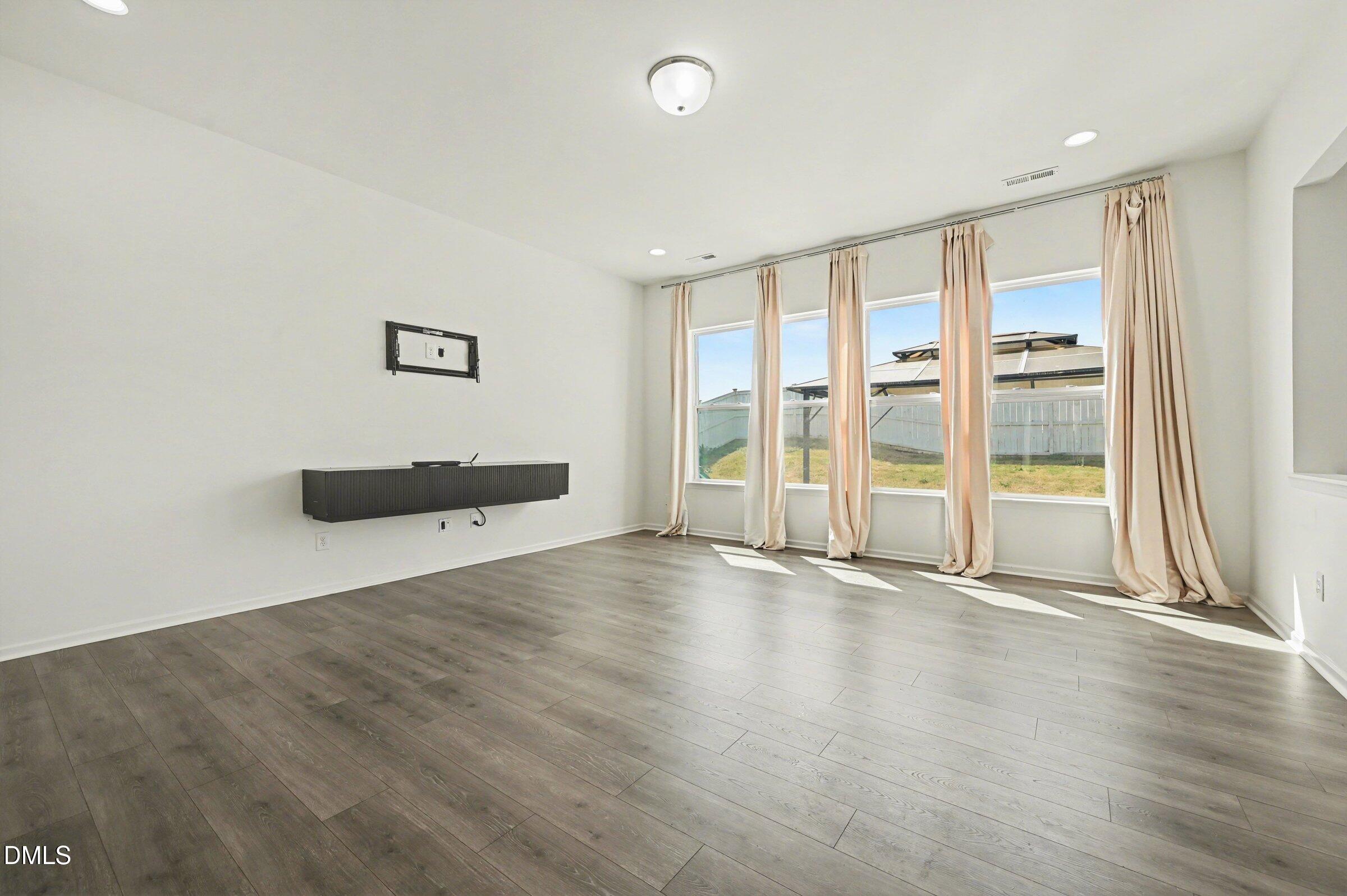 7015 Grainfield Road Mebane, NC 27302 - Photo 9 of 42 an empty room with wooden floor and windows
