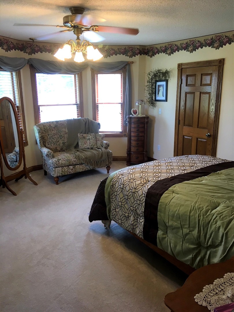6166 Ogle Road Polo, IL 61064 - Photo 24 of 32 a bedroom with a bed a couch and dresser