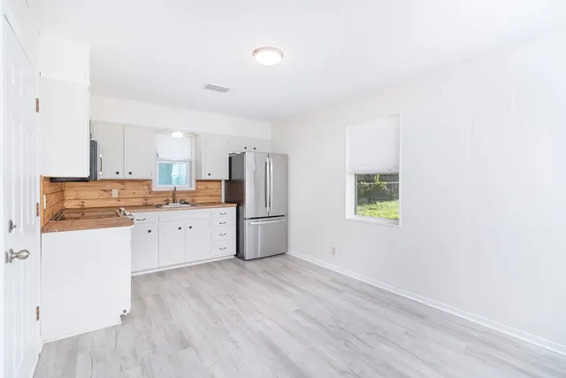a kitchen with stainless steel appliances a refrigerator sink and microwave