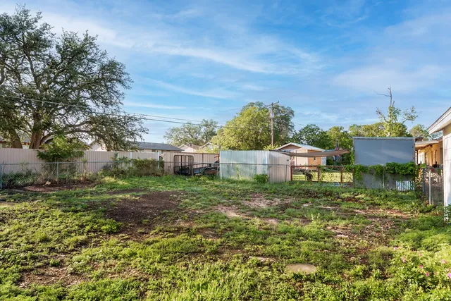 a view of a house with big yard and large trees