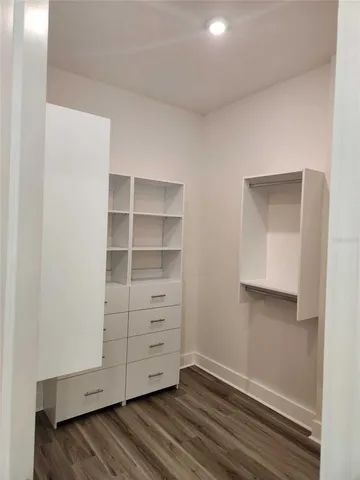 an empty room with wooden floor and entrance