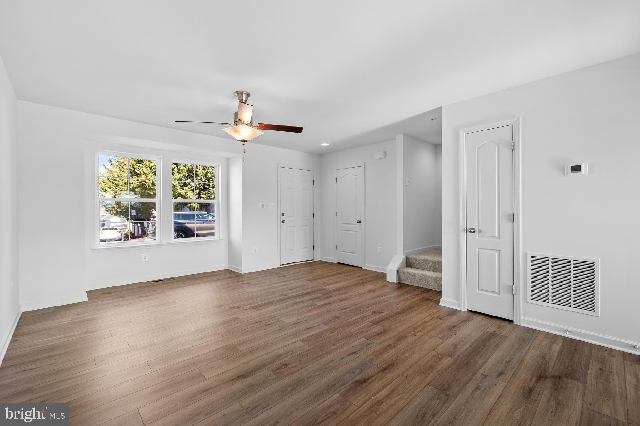 487 Peleton Street Hagerstown, MD 21740 - Photo 5 of 27 an empty room with wooden floor chandelier fan and windows