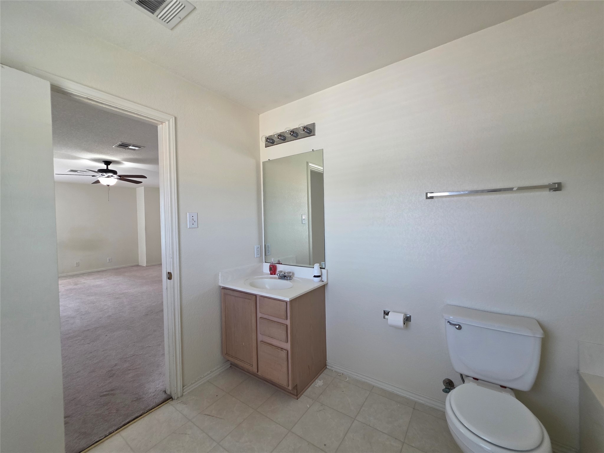 189 Ruidoso Road Kyle, TX 78640 - Photo 26 of 31 Well-lit bathroom features a single vanity and tiled flooring.