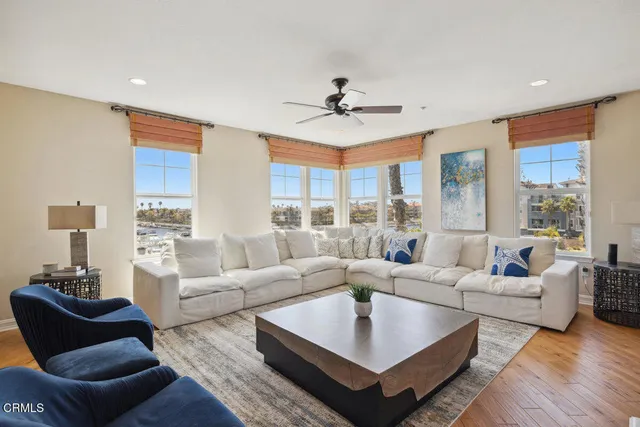 a living room with furniture wooden floor and a large window