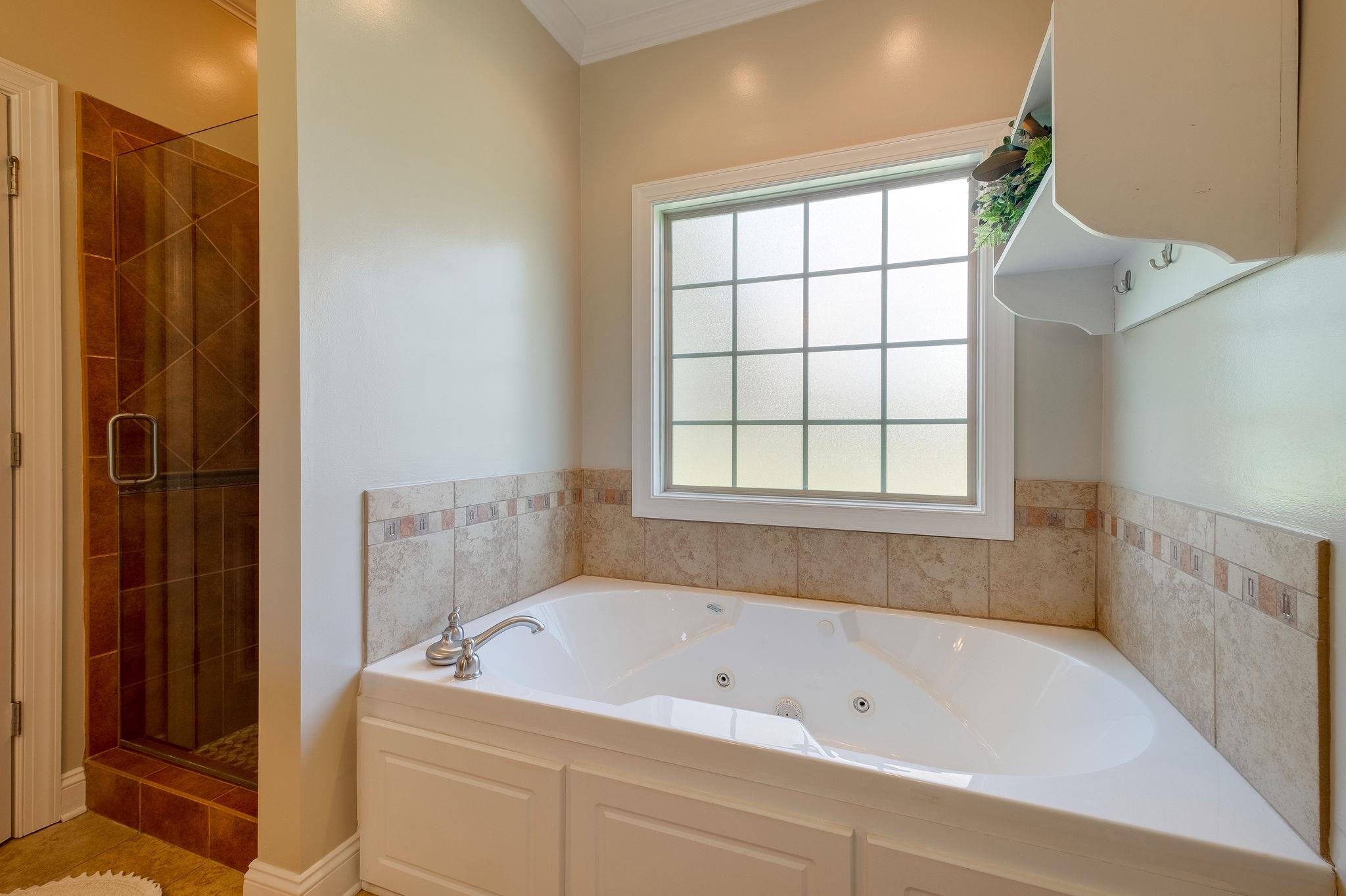 4110 Central Valley Road Murfreesboro, TN 37129 - Photo 13 of 30 Large jetted soaking tub and tiled shower. This bathroom has lots of light.