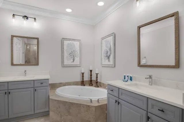 a bathroom with 2 sink tub and a mirror