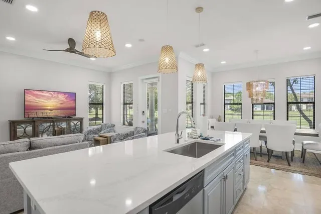 a kitchen with stainless steel appliances a sink and living room view