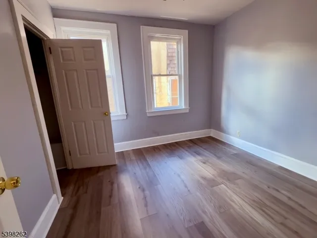 an empty room with wooden floor and window