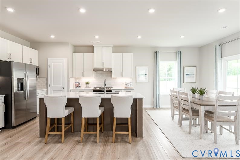 5 Driver Lane Richmond, VA 23223 - Photo 4 of 25 a large kitchen with kitchen island a dining table and chairs