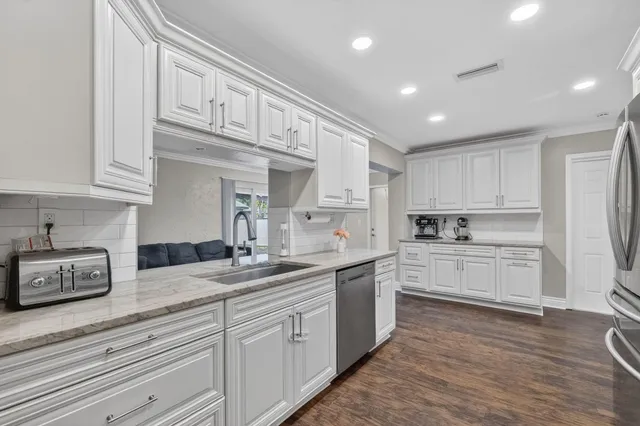 a kitchen with cabinets appliances a sink and a counter top space