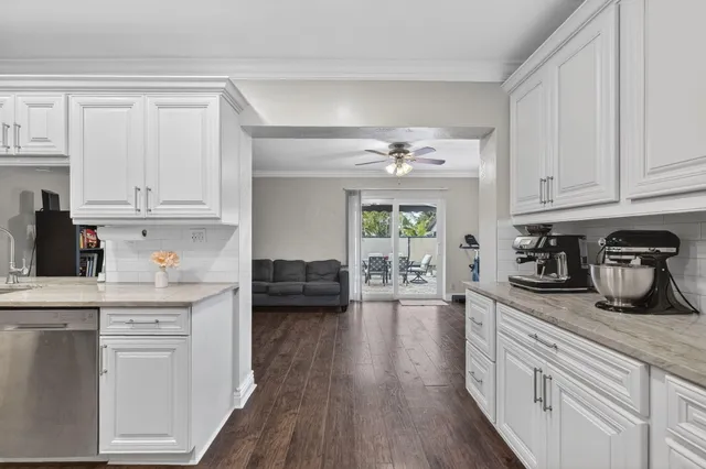 a kitchen with kitchen island granite countertop white cabinets and white appliances