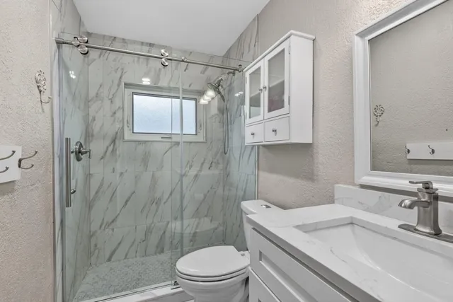 a bathroom with a sink a toilet and shower