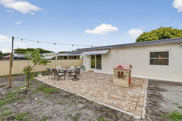 a backyard of a house with table and chairs